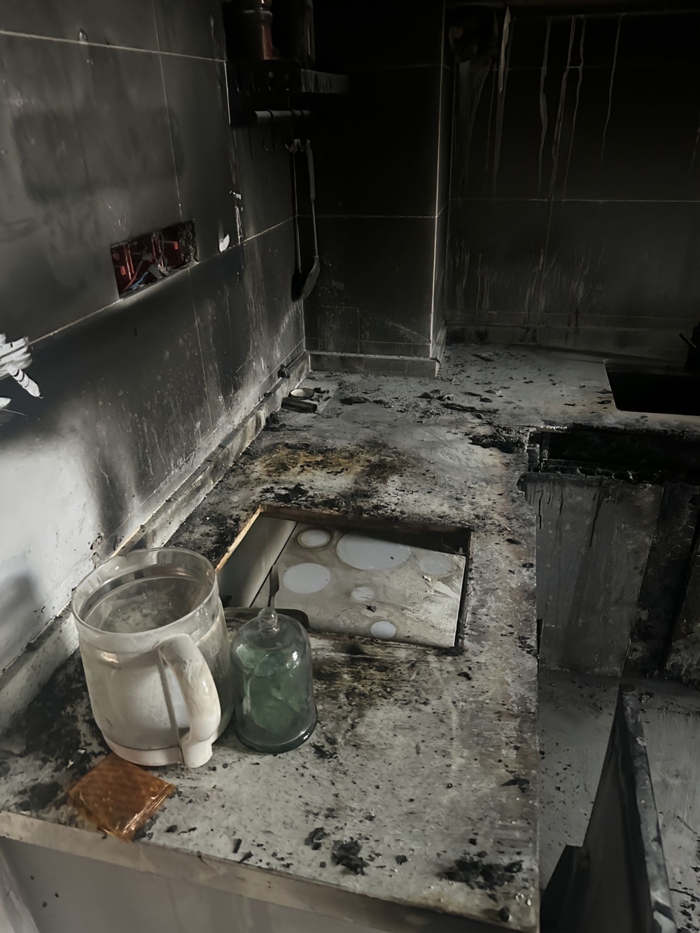 廚房一片狼藉，牆壁和天花板被燒得漆黑