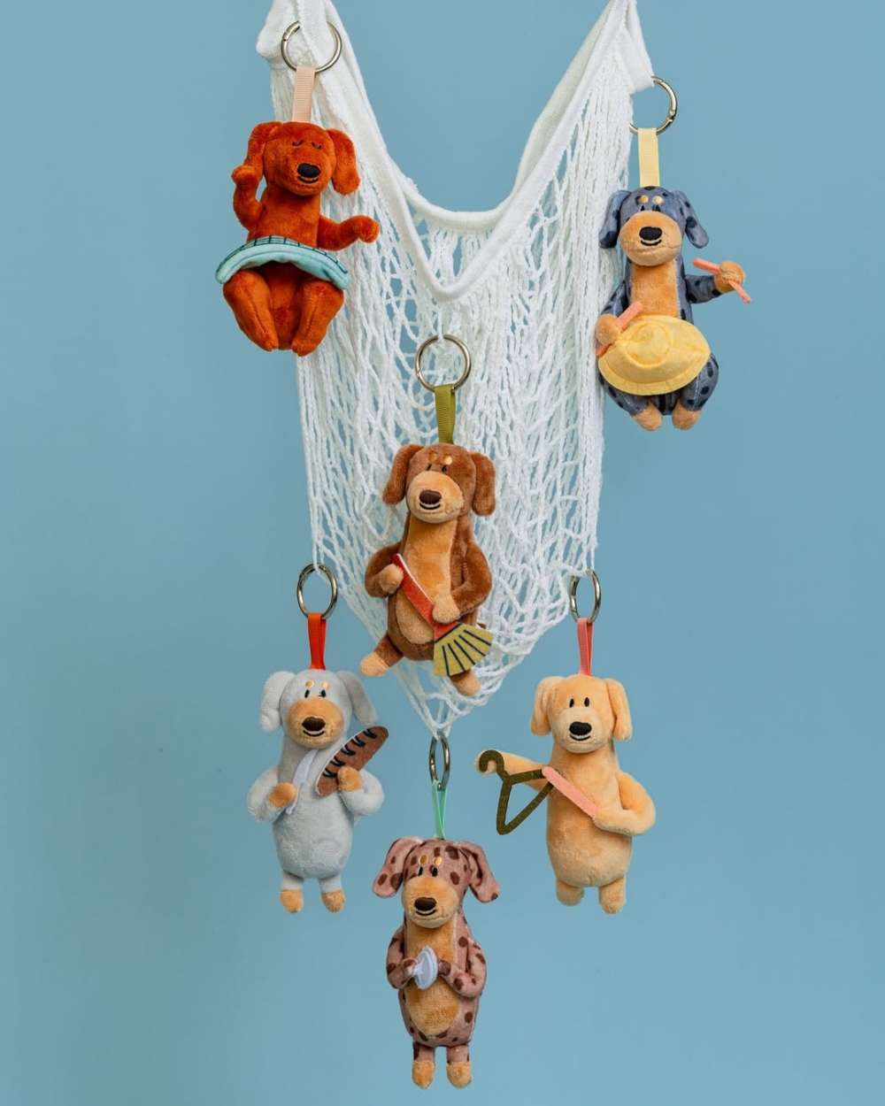 每一隻短腿臘腸狗都拿著不同的「生活用品」。