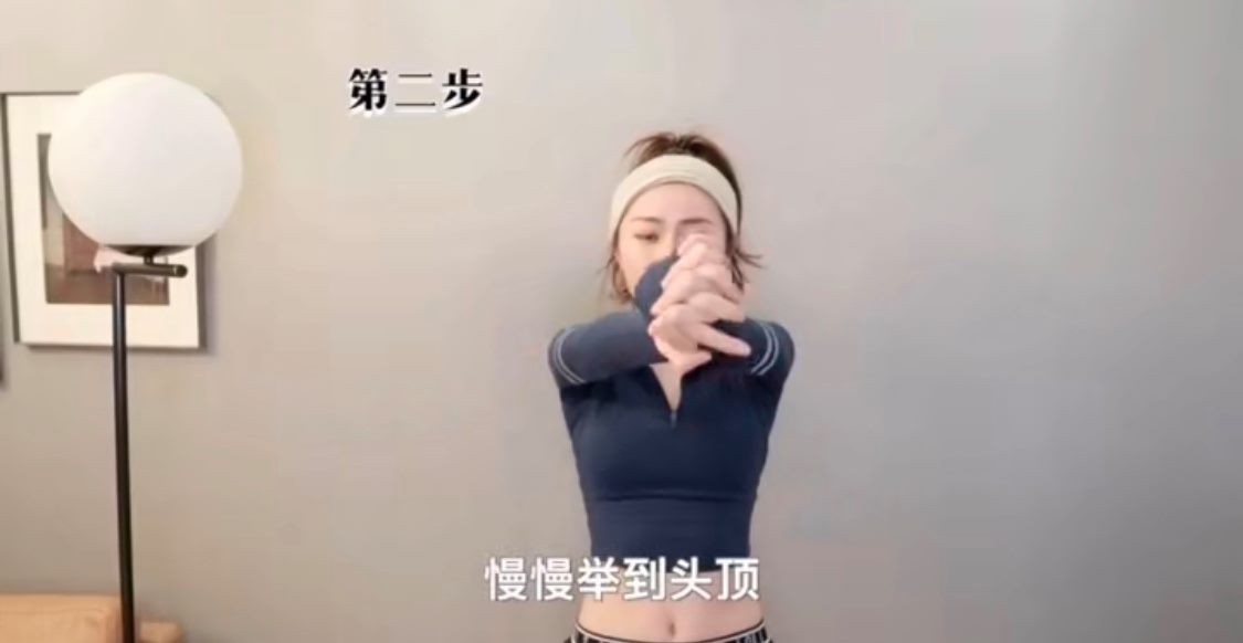 第二個動作,就是把手向前合十,然後舉到頭後伸直,然後慢慢在身旁打開。後背這個時候要用力。總共做三十下。