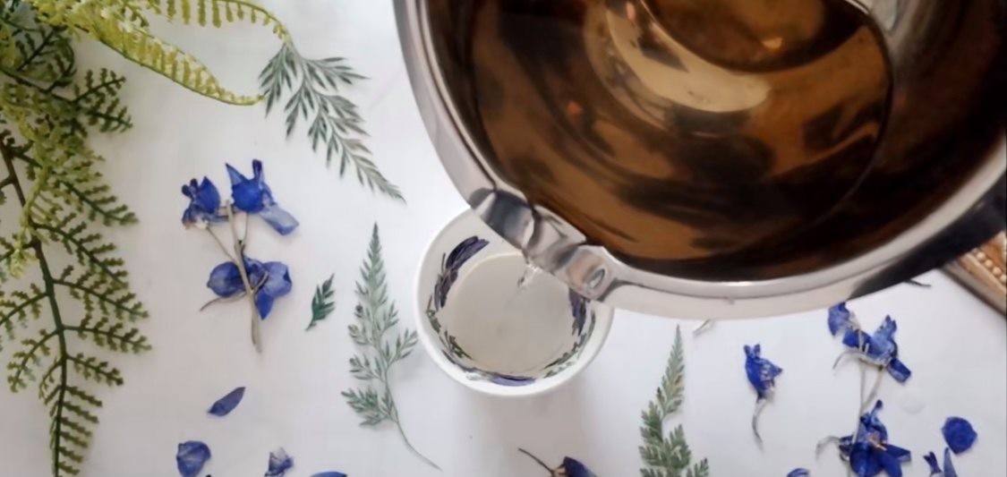 2.固定好乾花後,就可以再溶掉蠟。然後把變成液體的蠟倒進杯子裏,然後可以自選加不加入幾滴香薰精油。(注意:小心高溫蠟燭會燙到,最好找厚一點的紙杯防止過熱或會容易倒塌)