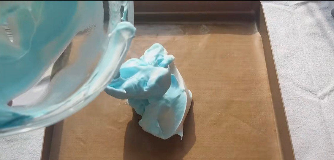 雲朵蛋糕-把打好的蛋白倒在鋪好牛油紙的烤盤上，把它盡量抹成球體狀或光滑的橢圓形狀。（想要有幾種顏色的話，就要分幾次打蛋白，然後在這一步把不同顏色的蛋白糊堆砌在一起！）