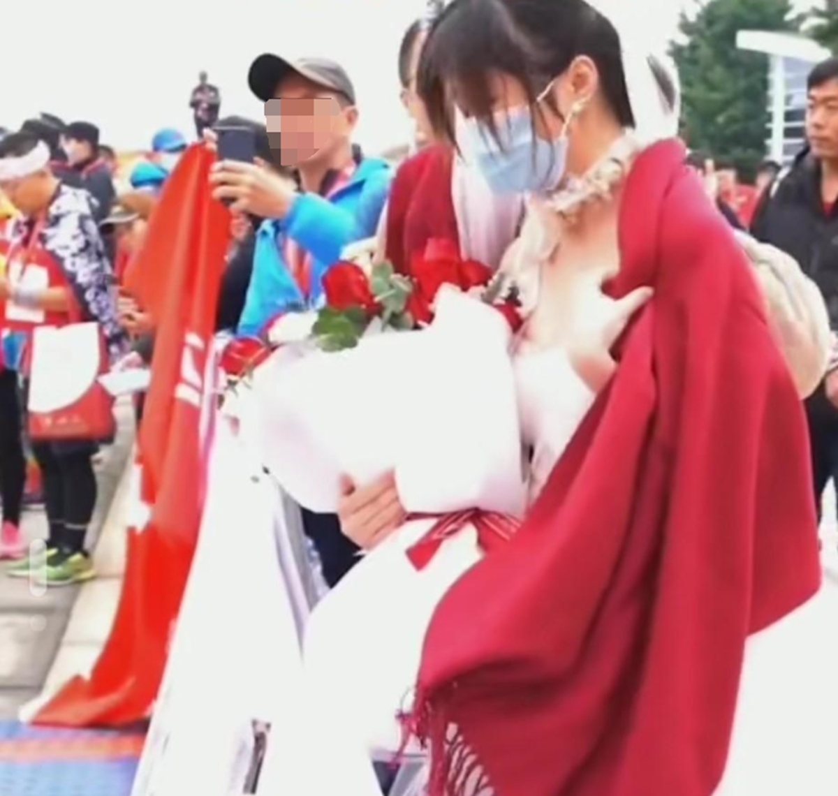 女生身穿單薄的婚紗已冷得瑟瑟發抖，她的好友見狀也只好連忙把身上的圍巾跟衣物都披在女方身上為她保暖。