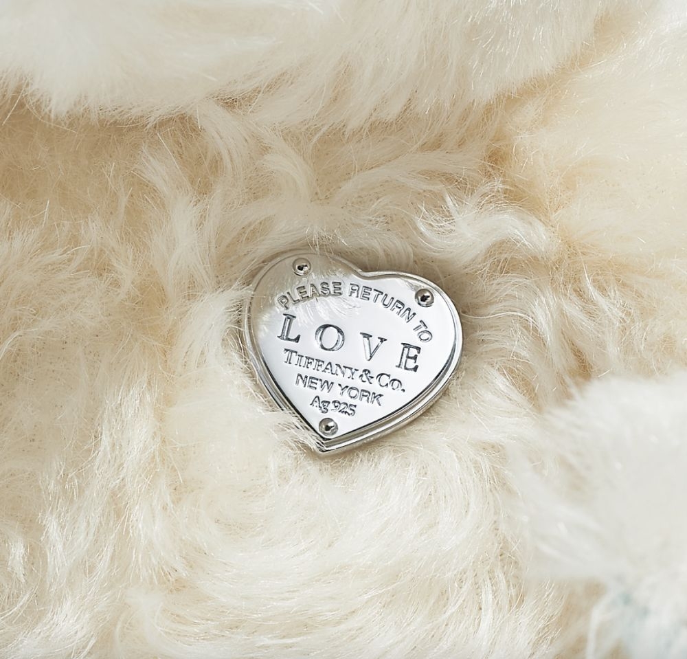 而在小熊的胸口位置則飾有以「Please Return to Tiffany Love 」雕刻而成的心型純銀吊飾