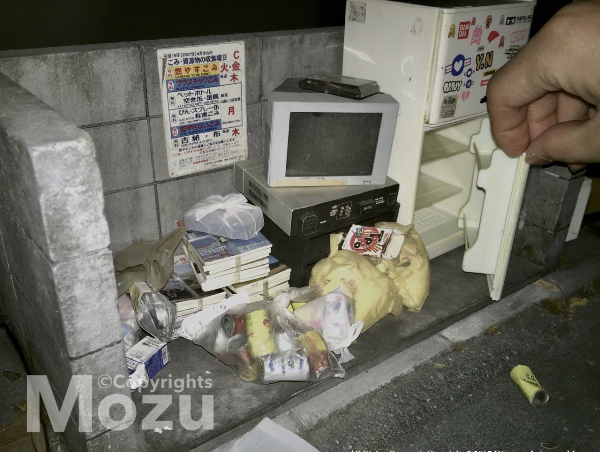 當中,戶外的裝置也完全難他不到,Mozu另一個十分厲害的作品還有「垃圾收集區」!這次換成戶外場景的路邊垃圾堆裏,有逼真的舊雪櫃與音響,就連泛黃的包裝盒與街上的污積也是一筆一筆畫上去的!