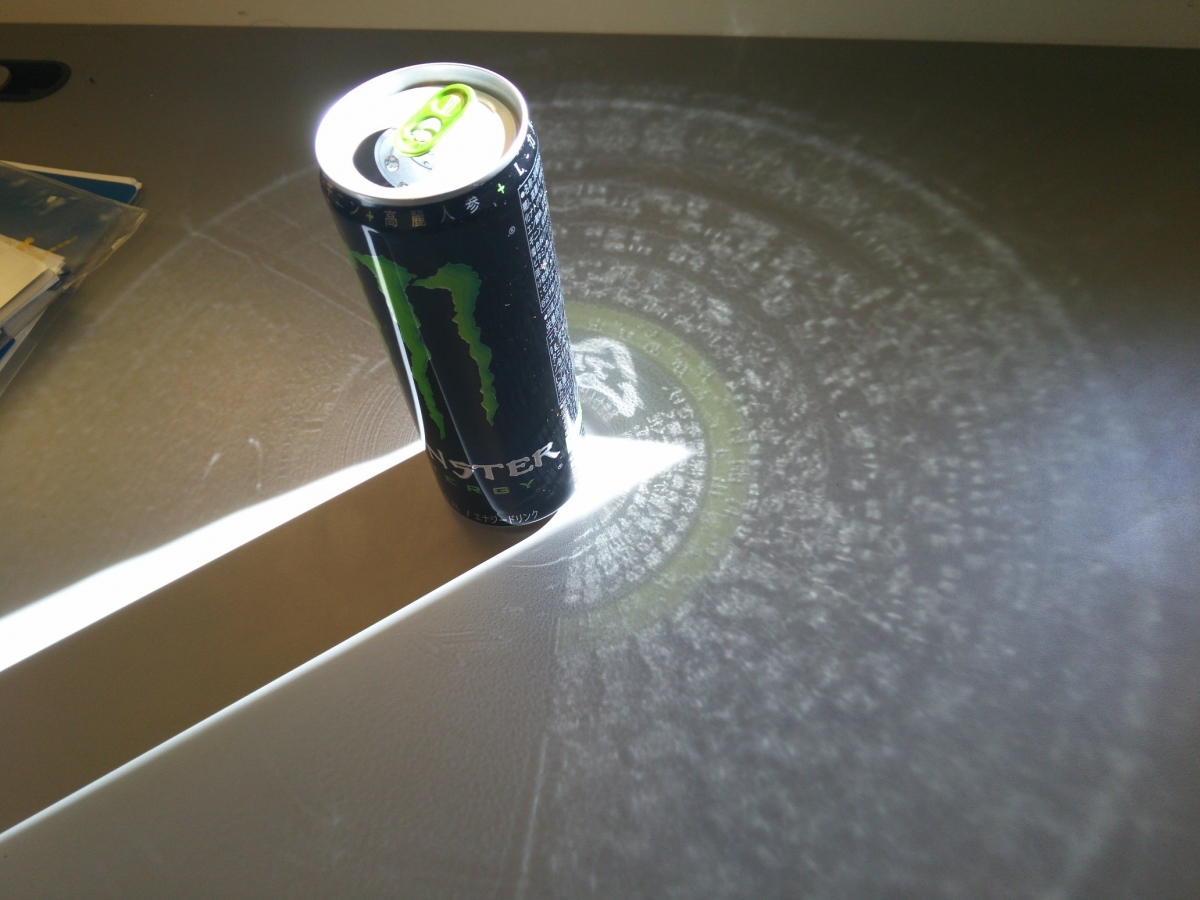 有網民就發揮創意把Monster飲品的鐵罐來試一下,而映照出來的就是迷離的細字,就像是充滿神秘力量的圖騰!細看原來是Monster罐子上的營養標籤被折射出來了,加上綠綠的反射,讓Monster飲品看起來超有邪惡力量,跟飲品的形象超配的!