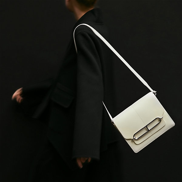 Hermès roulis 23手袋以簡潔的方正外形並飾金屬環形袋釦,標誌性的愛馬仕豬鼻子超吸睛,展現出低調奢華路線。