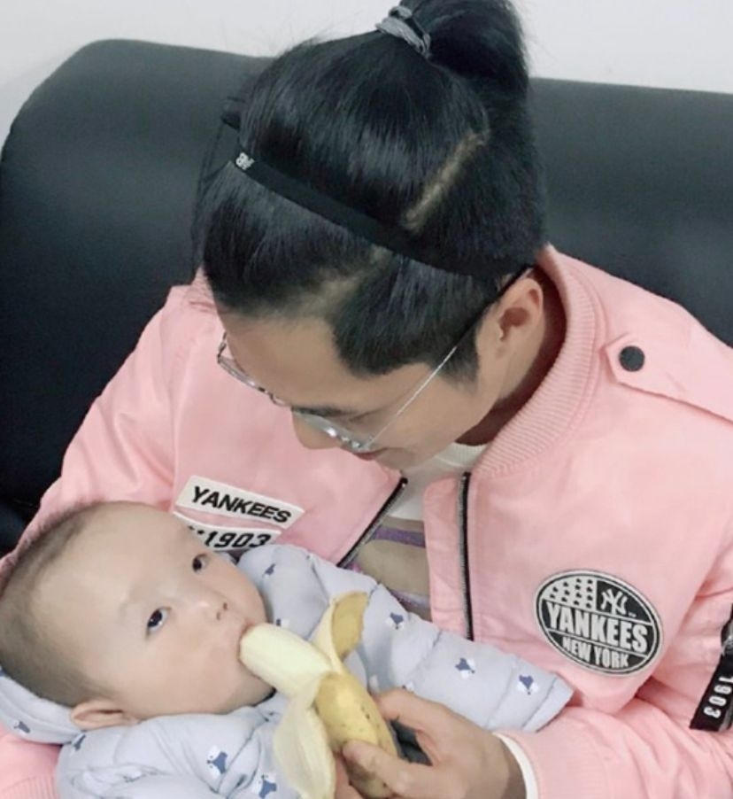 東京奧運開幕,短跑運動員穿粉紅色外套留有長髮紥起小辮