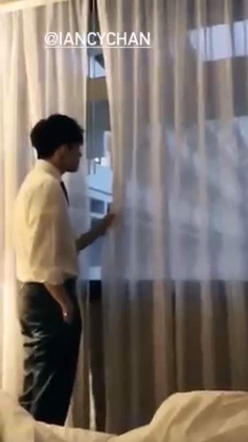 穿著恤衫的 Ian 則在窗邊輕掀窗簾望風景