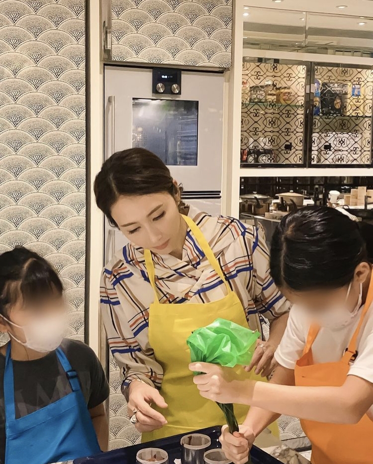 穿上黃色圍裙,束起頭髮的黎姿細心地從旁指導女兒