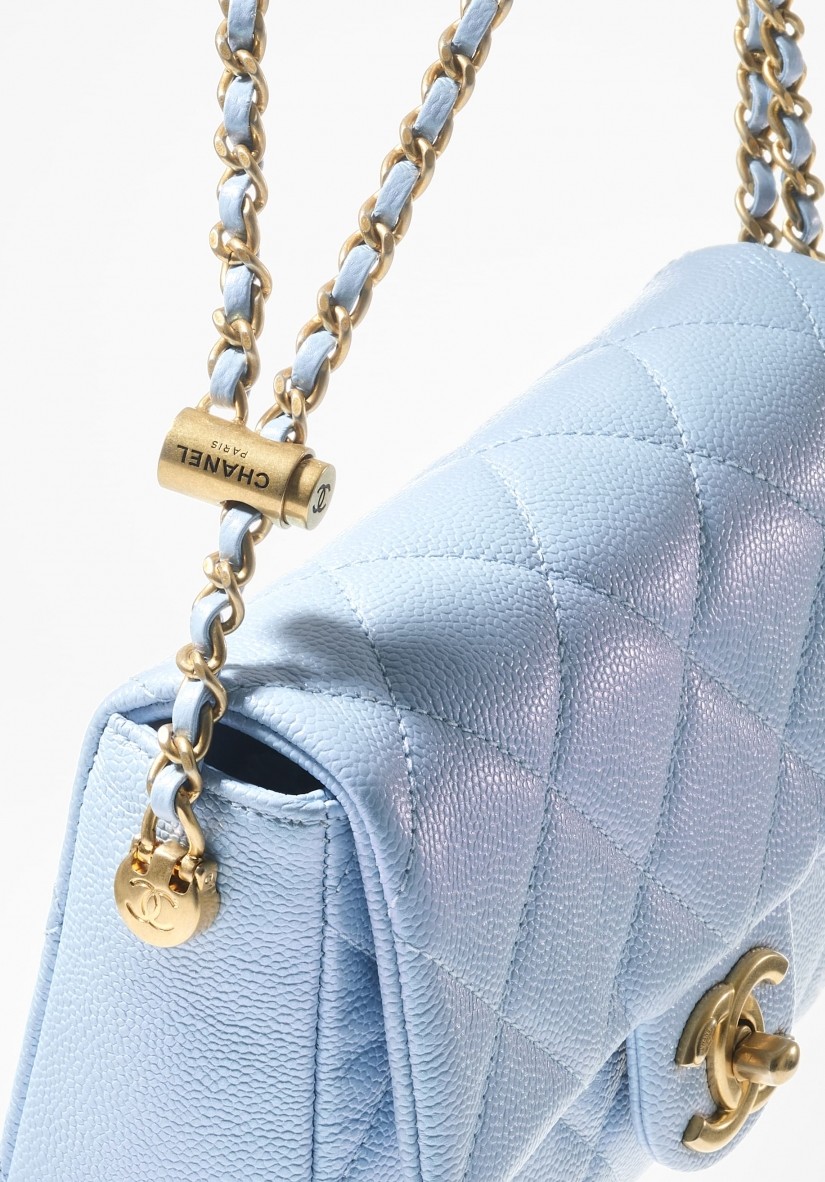 這款小巧精緻的淡藍色垂蓋手袋,就在鏈條上重新加入 Chanel 鈕釦元素,完全正中細節控的小心臟。