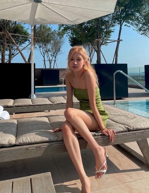 Rosé 更不忘到訪 Paradise City 最著名的泳池,她身穿青綠色微性感的連身裙子,坐在池邊的太陽椅拍照