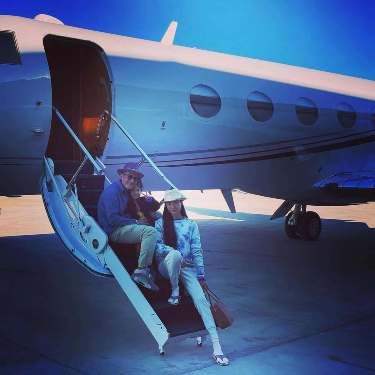 Alaia 的機上休息的一張相片，就被鄰座的名牌手袋和草帽搶鏡！