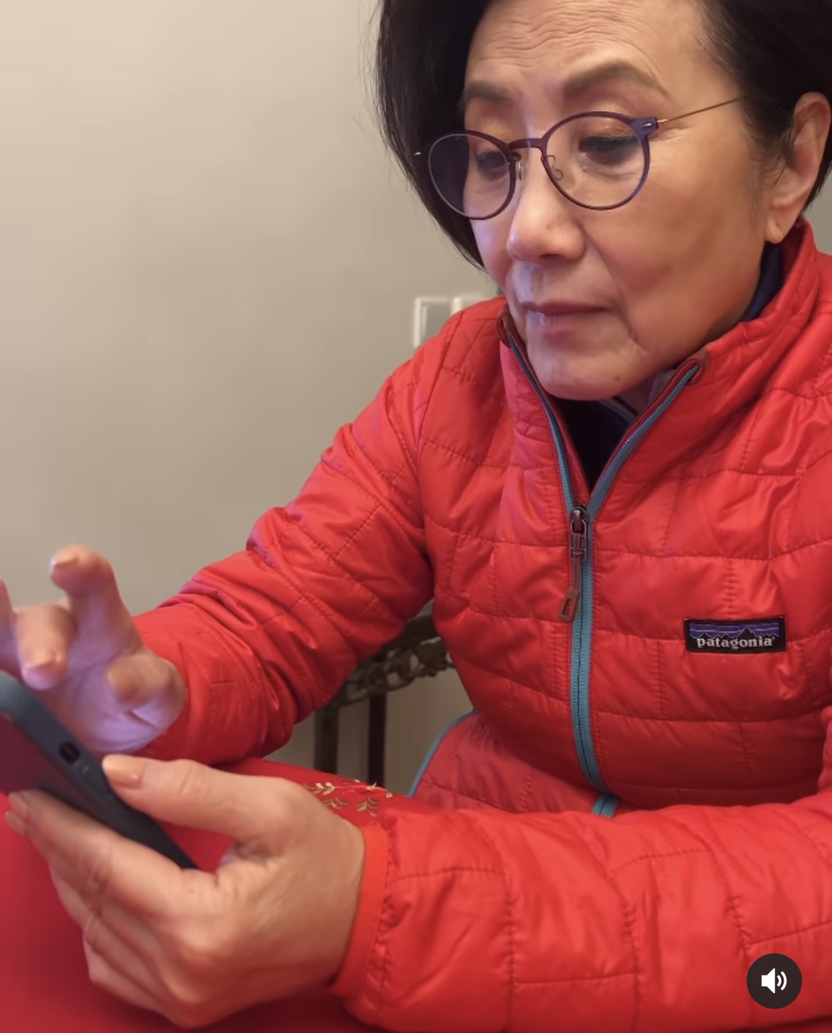 身穿紅色外套的阿姐拿着手機翻看網民的回應