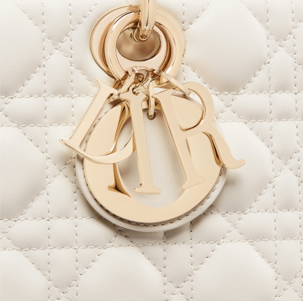 手提位置更綴有淡金色色調金屬「D.I.O.R.」吊飾