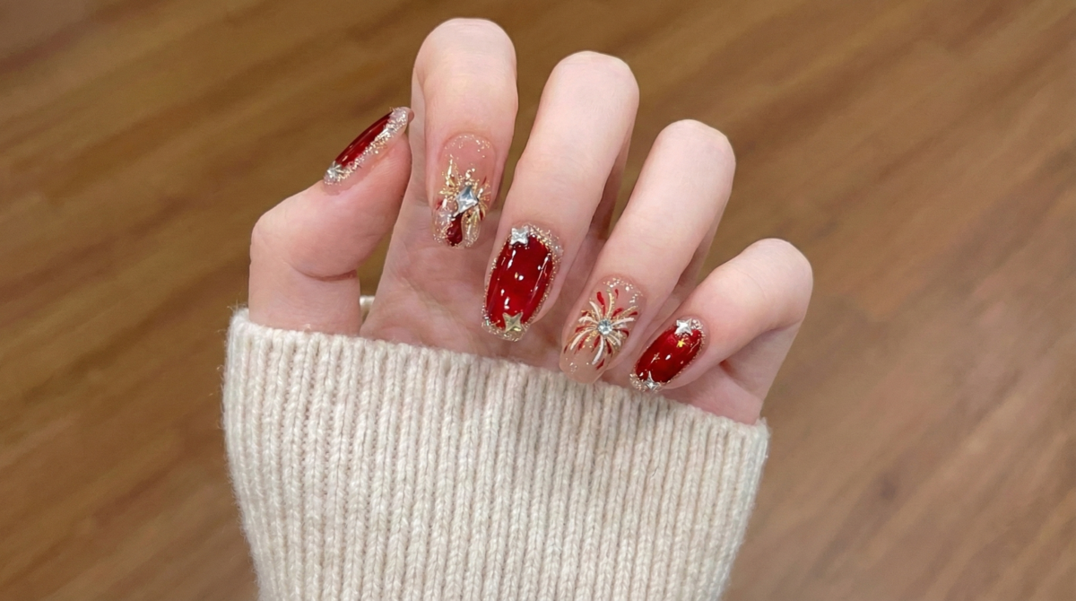 這款設計以手工繪製的煙花為主題，結合了節日紅、閃耀金和銀色線條，在指尖綻放光彩。