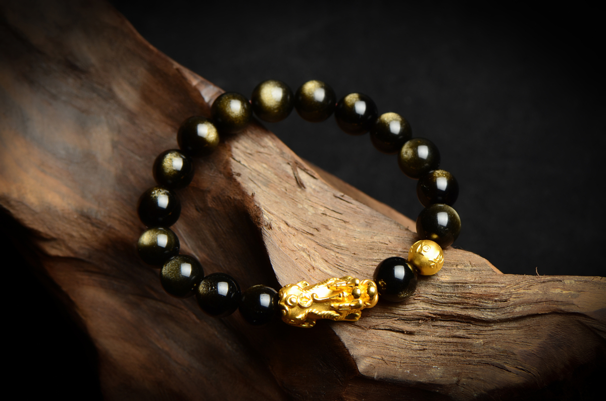 金曜石(Golden Obsidian)是一種特殊的黑曜石,屬於黑曜石家族中的珍貴品種,內含金色微粒,當光線照射時會反射出迷人的金色光芒。