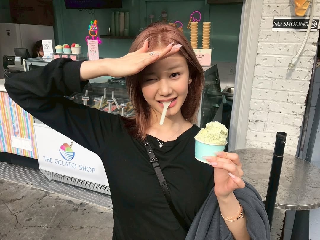 黑色 V 領長袖上衣的剪裁能拉長頸部線條，讓臉型看起來更精緻。