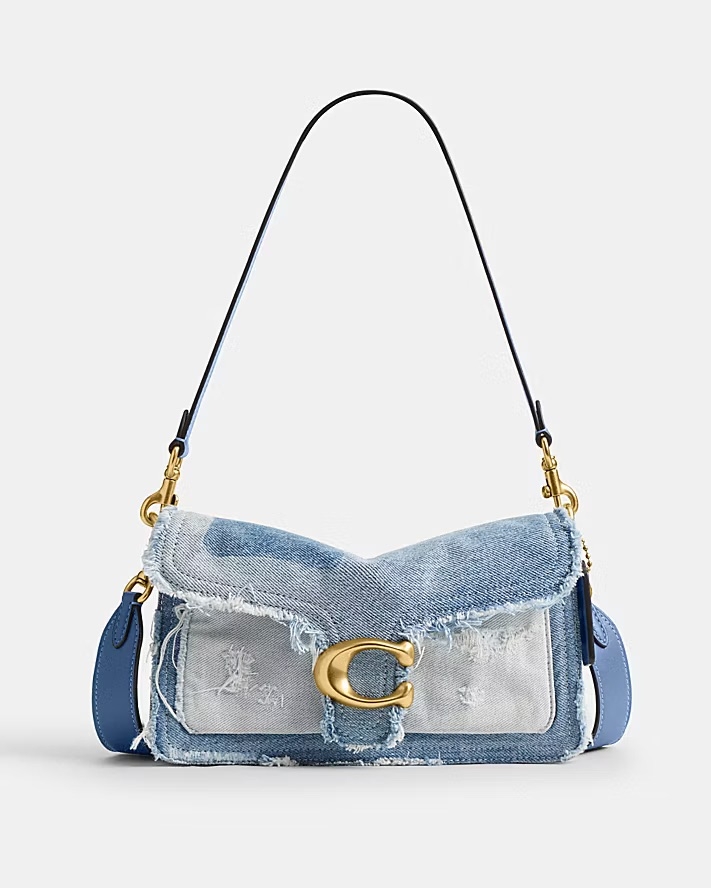 這款 Coach Tabby 26 丹寧拼接單肩手袋，以現代手法重塑 1970 年代的經典設計，揉合了復古情懷與街頭時尚。