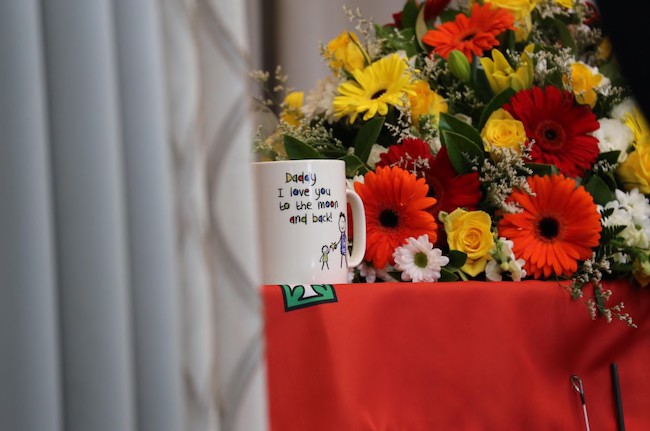 棺木上放咗一個印有「Daddy I love you to the moon and back!」嘅杯。