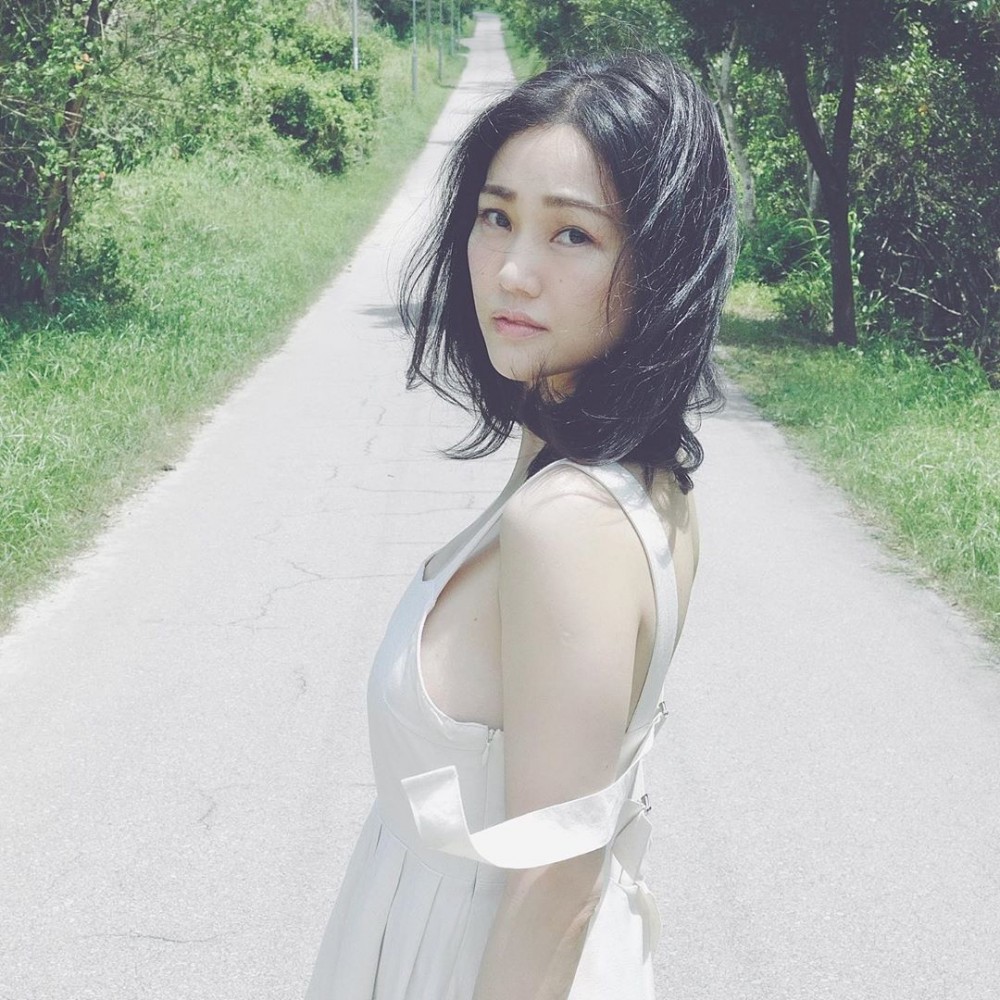 背景係郊外綠油油一片,美人配美景