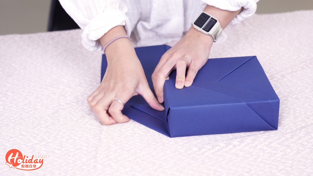 上面多餘部分向下摺，收好多餘花紙後，下面花紙再往上摺，用雙面膠紙貼實。