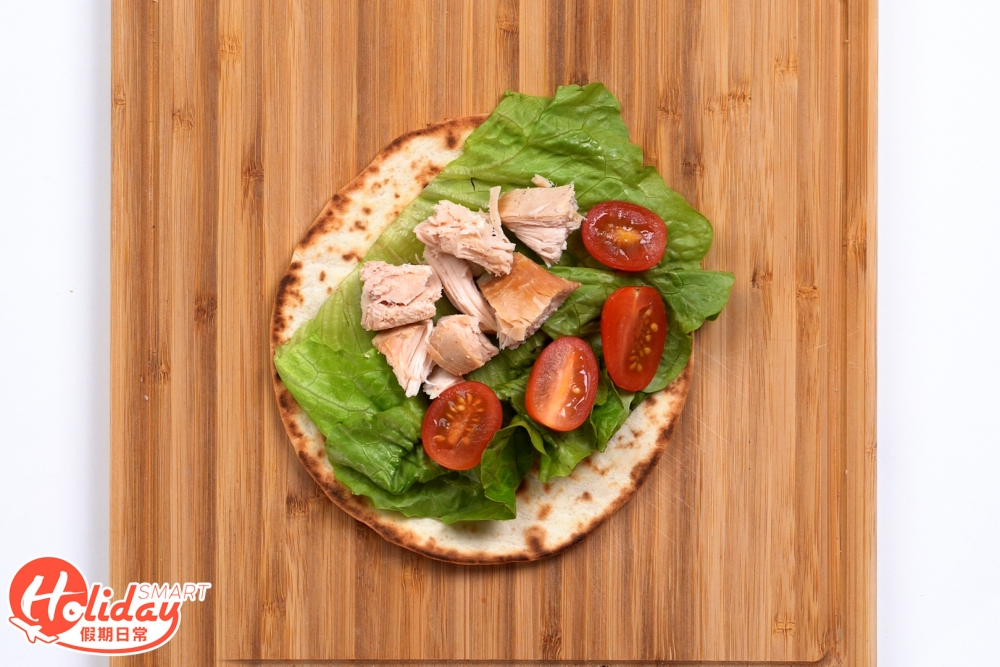 墨西哥捲餅放上雞肉、車厘茄及生菜,灑上少許鹽、胡椒粉,捲起來即成。