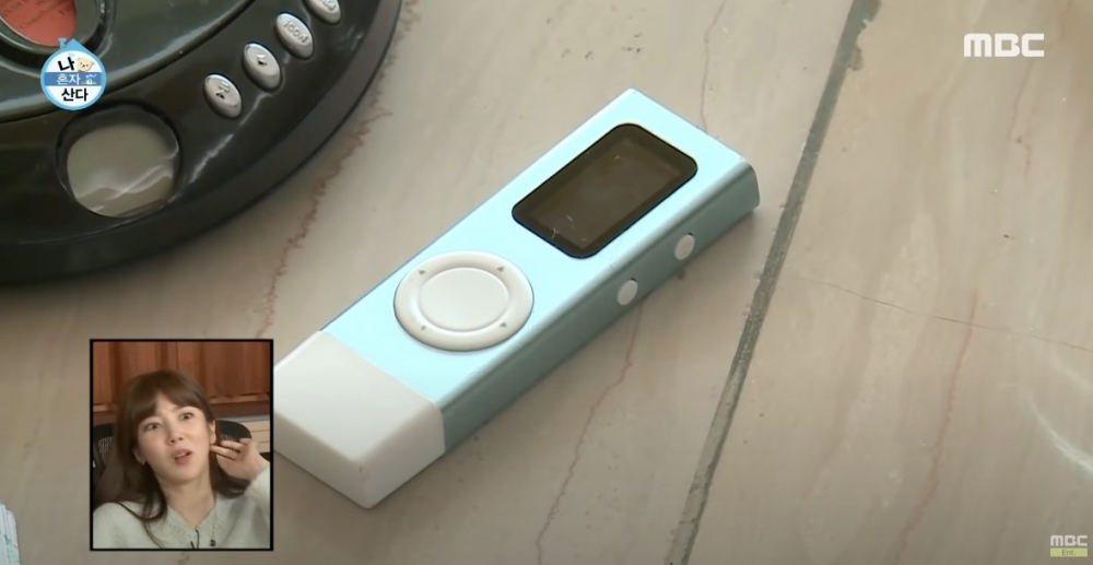 允浩整理時光膠囊,翻出好多復古物品,折疊式手提電話、MP3 等。