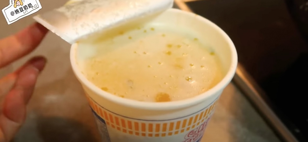 將融化咗嘅牛油倒入杯麵中浸泡。