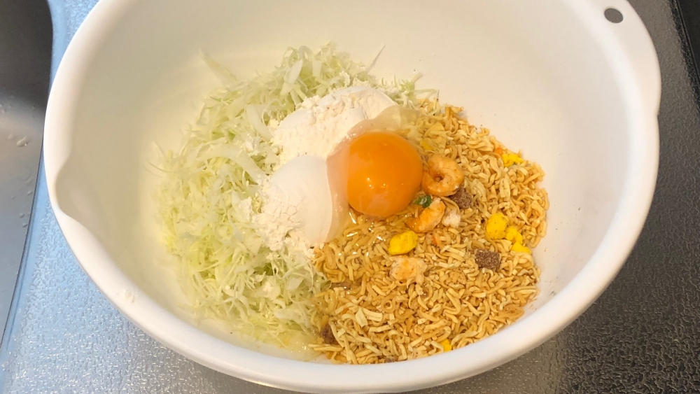 加入椰菜絲、雞蛋、麵粉及水，將所有材料攪勻。