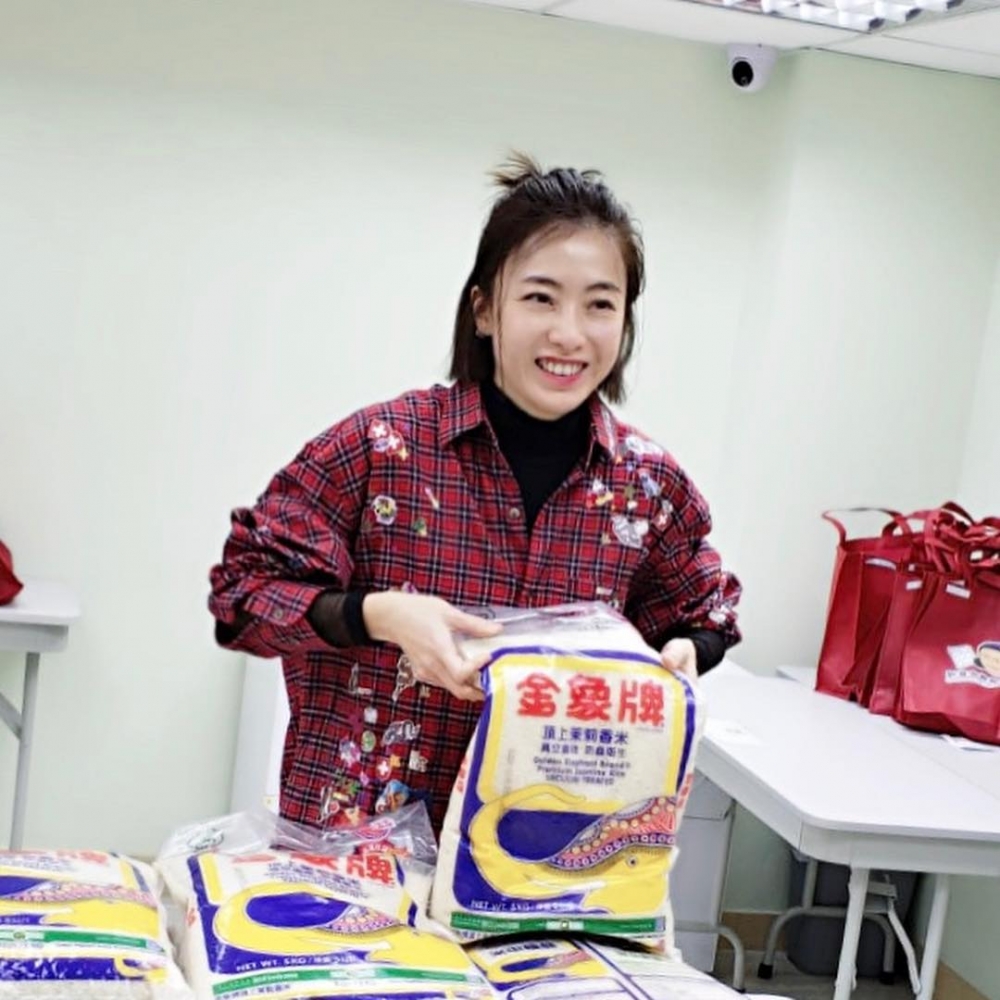 身為香港女首富嘅甘比更樂善好施,帶埋仔女派米做善事