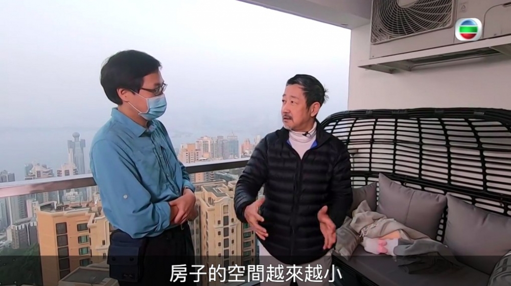Frankie同方東昇企喺露台,明顯可以飽覽維港景色