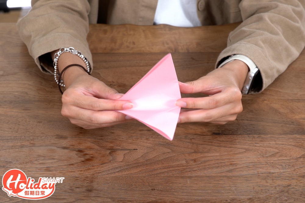 1.將正方形的顏色紙打斜對摺3次,摺成一個三角形。