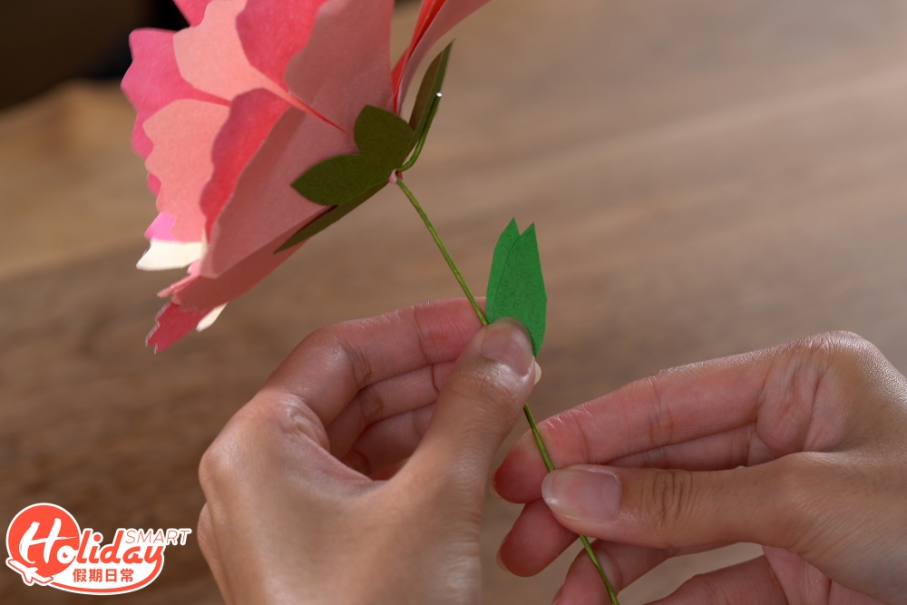 8.至於下面樹葉部分,將正方形的顏色紙打斜對摺2次,剪成樹葉的形狀,一次便可以剪出2塊樹葉,用膠水將樹葉黏在鐵線上就完成。