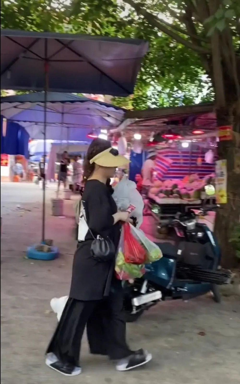 阿嬌就以全黑造型示人,oversize過臀上衣配寬鬆嘅黑色長褲,著黑色拖鞋,仲帶上黃色太陽帽,打扮低調。
