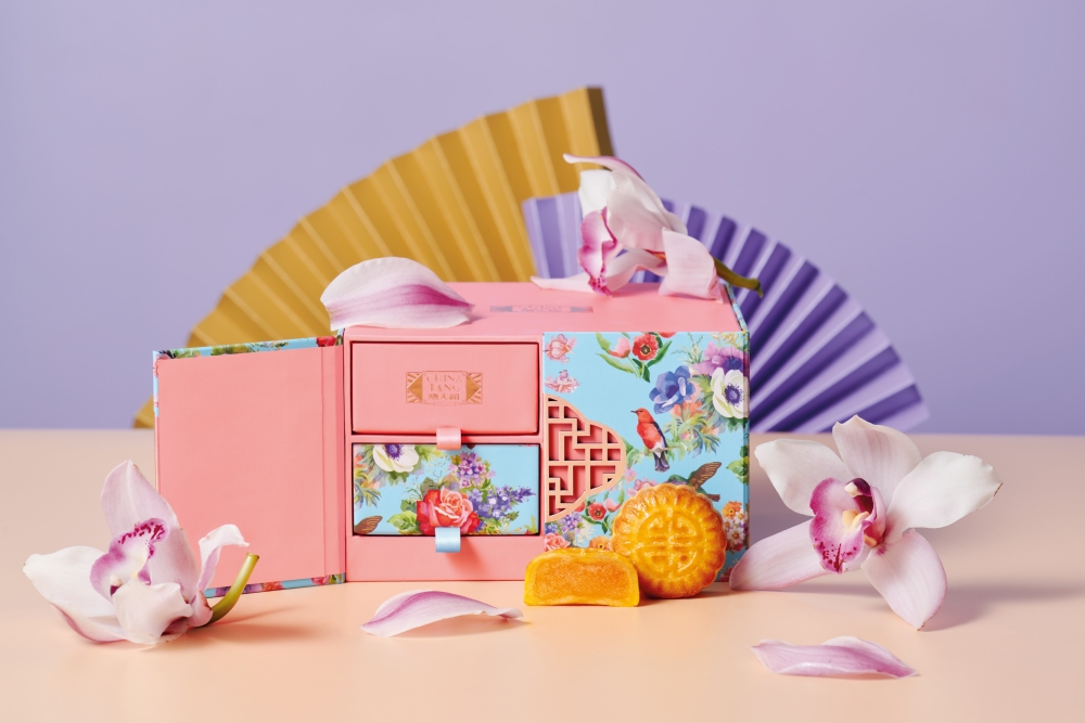 迷你匠心奶黃月餅則用上珊瑚粉紅與湖水藍拼撞而成的禮盒盛載，配上中式窗框和抽屜。