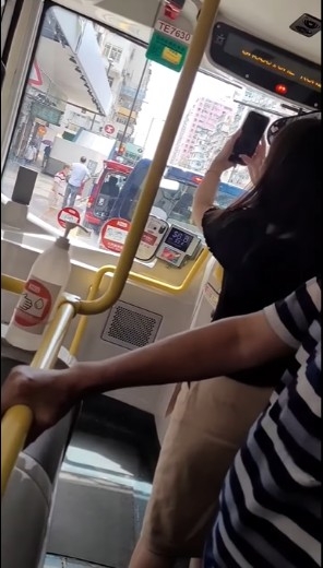 港女不時拿手機拍攝九巴情況及車長相貌