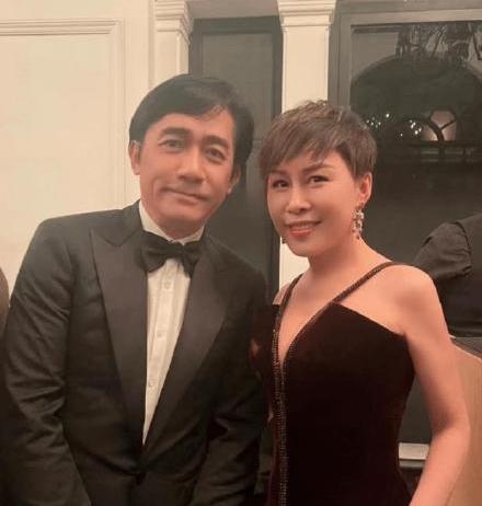 梁朝偉同女士合照明顯比較拘謹,雙手更安份放喺身前。