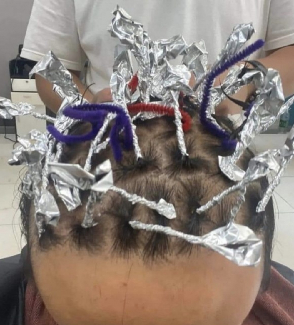 只見電髮時佢將頭髮捲起，同外國流行嘅雷鬼髮型有幾分相似！