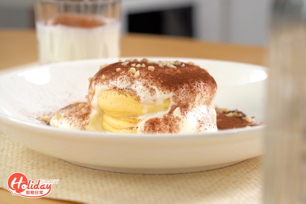 把雪櫃的淡忌廉倒在班戟上，最後灑上可可粉。