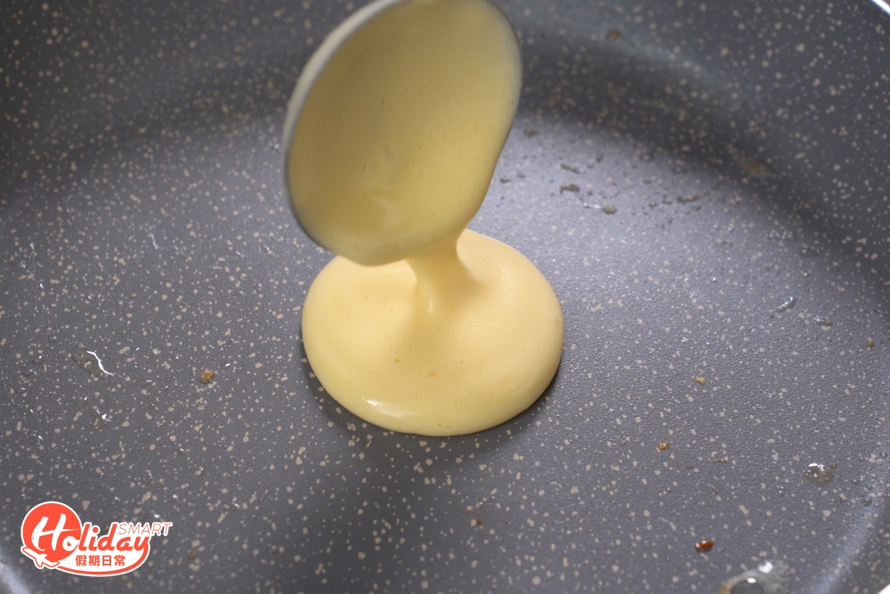 平底鑊塗上一層薄油，放一大匙麵糊於平底鑊中，旁邊加入一兩滴清水，加蓋細火煎焗一分鐘。