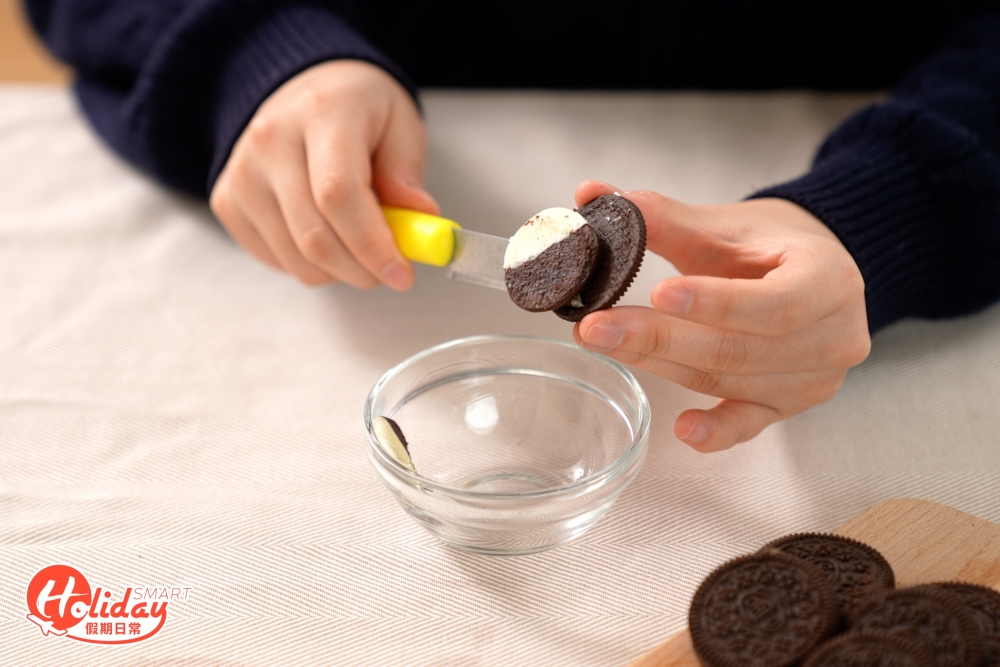 把OREO夾心餡料挖走,再把OREO朱古力餅乾壓碎。