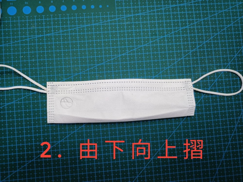 把口罩下半部往上摺。