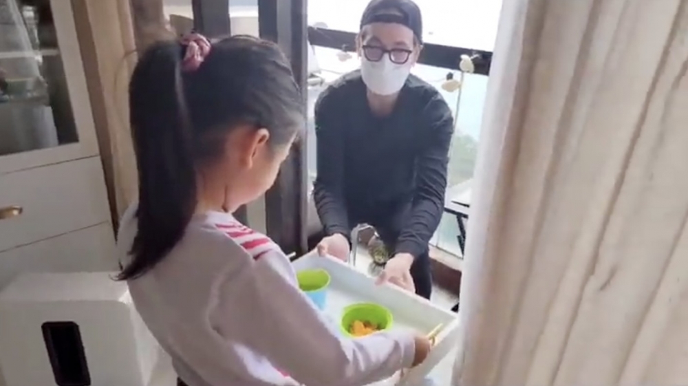 陳豪細女Camilla喺餐盤上放咗啲小食送去畀坐喺露台嘅爸爸