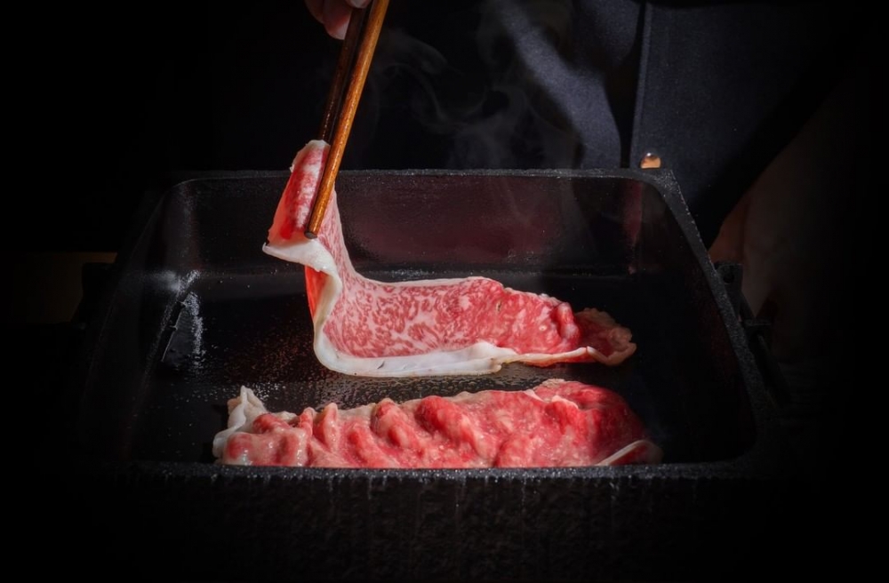 師傅會在餐桌前即席烹調,以日本關西地區的傳統烹調,先以牛油起鍋,放入油花滿瀉的和牛,淋上醬汁烤至半熟。