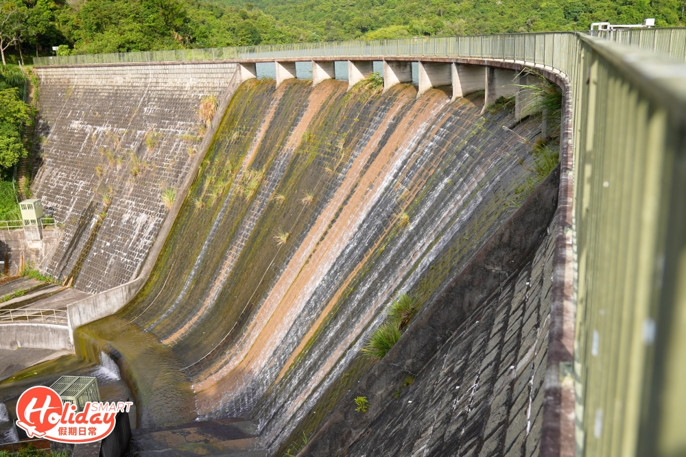 水壩左邊是高17.4米的排水口，可看到藝術感十足的石級，入口左邊更有一條小徑可通往壩底，河背水塘曾入選為漁農及自然護理署的郊野公園十大自然風景之一。