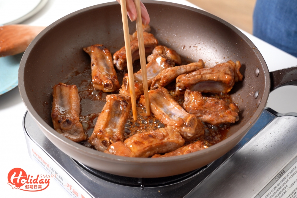 用小火炒至金黃糖色,之後再倒入豬肋骨再炒均匀。
