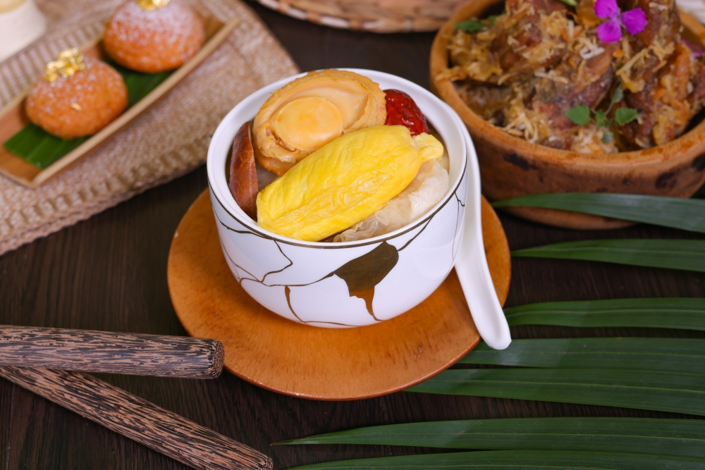 貓山王榴槤鮑魚紅棗白玉銀耳燉湯加入老雞先熬製3小時，再加入榴槤、智利八頭鮑魚、雪耳、冬瓜、紅棗等再熬製3小時，確保湯頭香醇順滑，清甜滋潤。