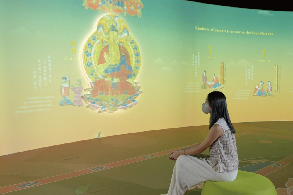 「報父母恩重經變」15則連環故事圖以數碼展示於大螢幕放映，大家嚟到可以坐低慢慢了解故事。