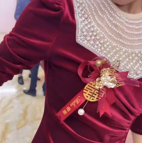 後來女士先發現「新娘」心口嘅襟花寫住「媽媽」！