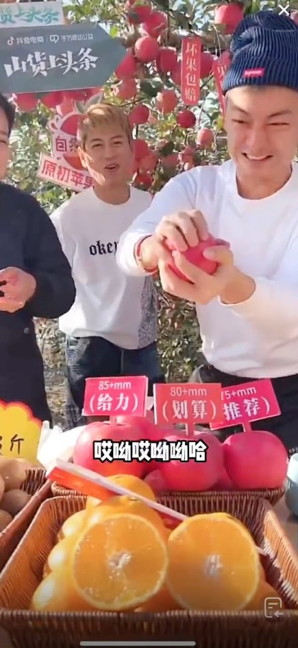 梁競徽直播帶貨賣生果,首先佢就大讚蘋果多汁又爽脆,此時旁邊嘅女士就用手摵開個蘋果,梁競徽有樣學樣